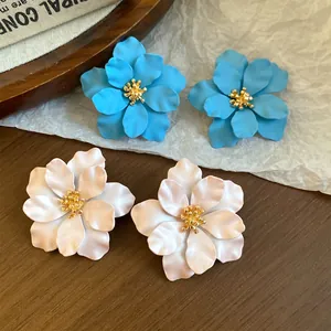 Detailansicht der eleganten mattblauen und perlmuttweißen Blumenohrstecker im französischen Stil