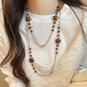 Detailed view showing the layered Maillard vintage necklace with wooden star beads and amber crystals