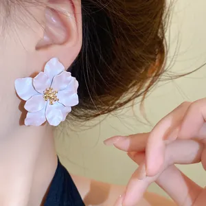 Detaillierte Nahaufnahme eines eleganten weißen Blumen-Ohrsteckers am Ohr eines Models