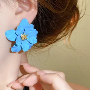 Nahaufnahme eines stilvollen französischen blauen Blumenohrrings mit mattem Finish