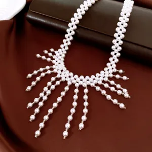 Macro view of vintage style handmade white pearl fringe necklace on brown fabric