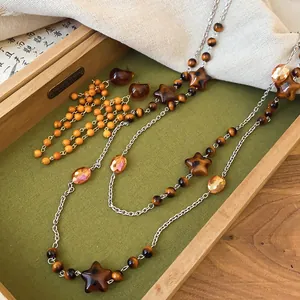 Detail view of vintage Maillard style brown beaded necklace and earrings with star charms