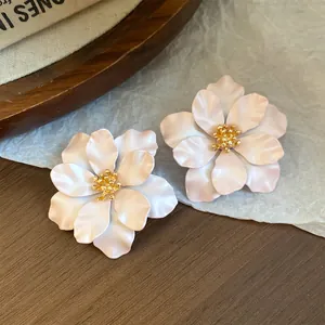Detailansicht französischer Blumenohrstecker mit zarten matten Blütenblättern und Goldmitte.