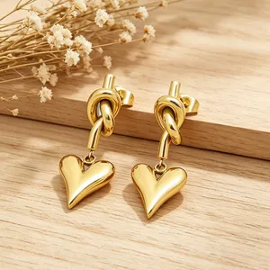 Elegant gold-plated stainless steel knot and heart drop earrings for women on wood
