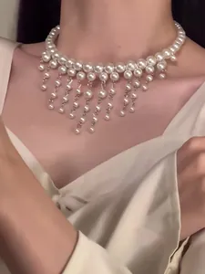 Close-up detail of a lustrous multi-row pearl choker featuring elegant beaded tassel drops