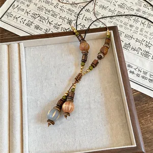 Detailansicht einer Vintage-Pulloverkette mit ethnischen Holz- und Muschelperlen-Akzenten