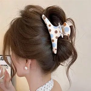 Dettaglio ravvicinato di una molletta per capelli a pois, acconciata perfettamente in uno chignon
