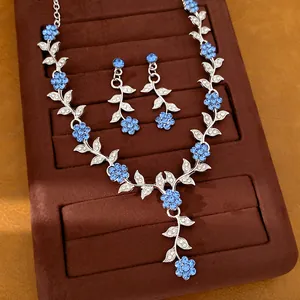 Macrobeeld van een luxe zilveren sieradenset met blauwe bloem- en bladpatronen van strass