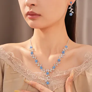 Detailopname van elegante blauwe bloemen strass ketting en bijpassende oorbellen set