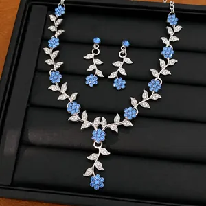 Prachtige sieradenset met bladeren en bloemen en blauwe strass-steentjes op blad.