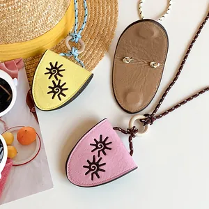 Detail view of colorful rope leather pendant necklaces with embroidered sun patterns.
