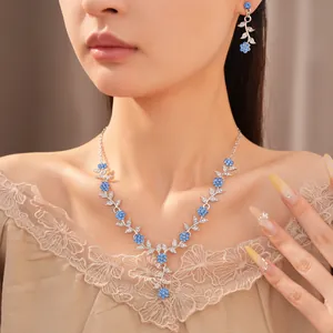 Gedetailleerd overzicht van elegante sieradenset met strass-bladeren en blauwe bloemen
