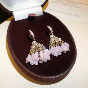 Vue rapprochée de boucles d'oreilles bohèmes avec pampilles en cristal rose et zircon