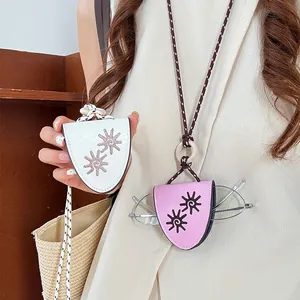 Macro detail of white and pink leather flower eyeglass holder pendants worn by model.