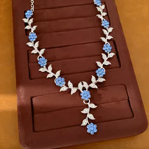 Macro-opname van een elegante zilverkleurige ketting met blauwe kristallen bloemen