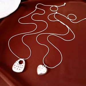 Dettaglio delle collane in argento a cuore e ovali con finitura opaca e motivi a pois