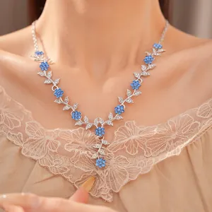Gedetailleerde close-up van een elegante zilveren bloemenketting met blauwe strass-stenen
