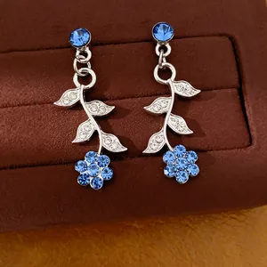 Gedetailleerde opname van prachtige blauwe strass oorbellen met blad- en bloemmotieven