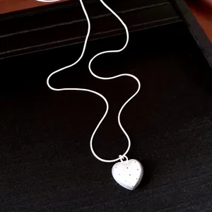 Primo piano dettagliato del ciondolo a cuore in argento con motivo a pois su catena