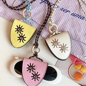 Close-up of bohemian leather sunglasses holder necklace with decorative sun pattern detail