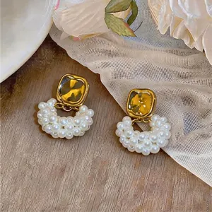 Elegante goldene quadratische Ohrstecker mit weißen perlenbesetzten kreisförmigen Anhängern