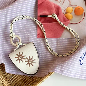 Close-up detail of niche leather necklace with sun flower embroidery and rope cord