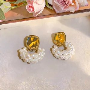 Elegante Ohrstecker aus Gold und Perlen mit einem klassischen Luxus-Vintage-Design.
