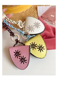 Close-up of leather sun flower pendants with colorful braided ropes and wooden rings