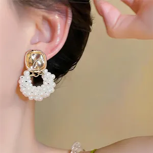 Vue détaillée d'élégantes boucles d'oreilles pendantes en perles sur une oreille
