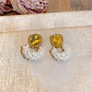 Détail de boucles d'oreilles perles élégantes avec haut en métal martelé doré