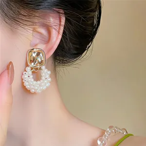 Vue détaillée de boucles d'oreilles pendantes en perles avec cristal et métal doré