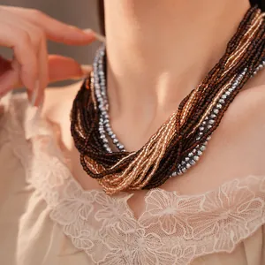 Détail d'un collier multi-rangs sophistiqué en perles de verre marron et dorées
