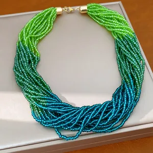 Gros plan d'un collier de perles de verre multicouche dégradé avec fermoir doré