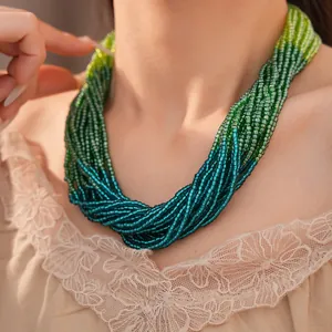 Vue détaillée d'un collier multicouche en perles de verre dégradé vert sur mannequin