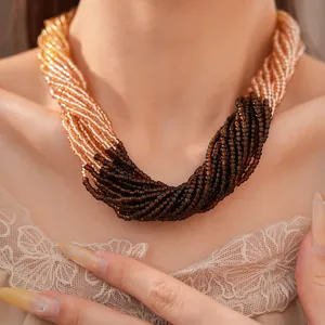 Vue détaillée d'un collier multicouche en perles de verre tons champagne et brun.
