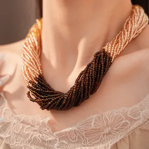 Vue détaillée d'un collier de perles en verre multicouche aux tons champagne et marron foncé