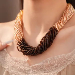Vue rapprochée détaillée d'un collier multi-rangs en perles de verre ambre et marron