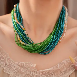 Vue détaillée d'un collier multicouches en perles de verre vertes et bleues sur le modèle