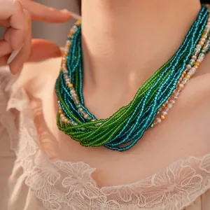 Détail macro d'un collier de perles de verre vertes multicouches de style vintage porté