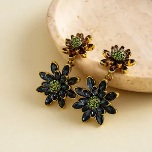 Detail van vintage oorbellen met dubbele bloemen en blauwe en paarse kristallen