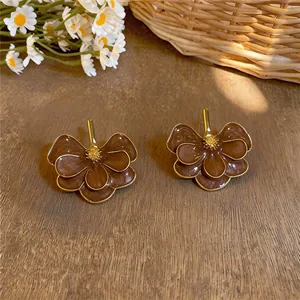Detailed view of vintage brown enamel flower earrings on a wooden background