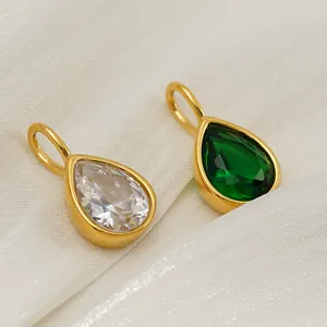 Macro view of gold-plated teardrop pendants with emerald and white zircon stones