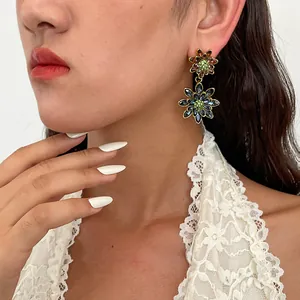 Detailopname van model met vintage dubbellaagse bloemen oorbellen met strass steentjes