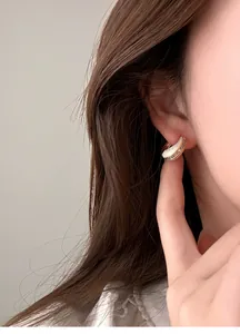 Detailansicht französischer Vintage-Goldohrring mit funkelnden Zirkonia-Einlagen am Ohr