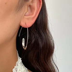 Minimalist silver C-shaped geometric hook earring shown worn on ear for detail