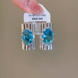 Gedetailleerde weergave van luxe ovale oorknopjes met sprankelende ijsblauwe zirkoon