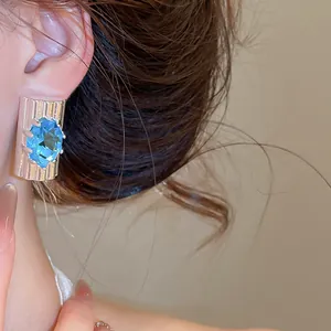 Detailopname van elegante ijsblauwe zirkoon oorsteker op een zilveren basis