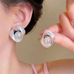 Pendientes retro de plata retorcida con perla elegante mostrados en una modelo