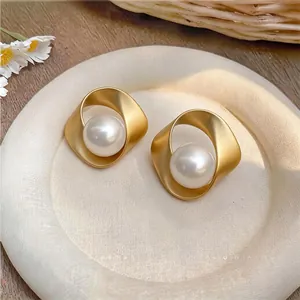 Dettaglio di eleganti orecchini retrò francesi in oro attorcigliato con perle bianche