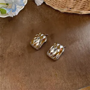 Nahaufnahme eleganter quadratischer Ohrstecker mit schimmerndem Rautenmuster im Facettenschliff
